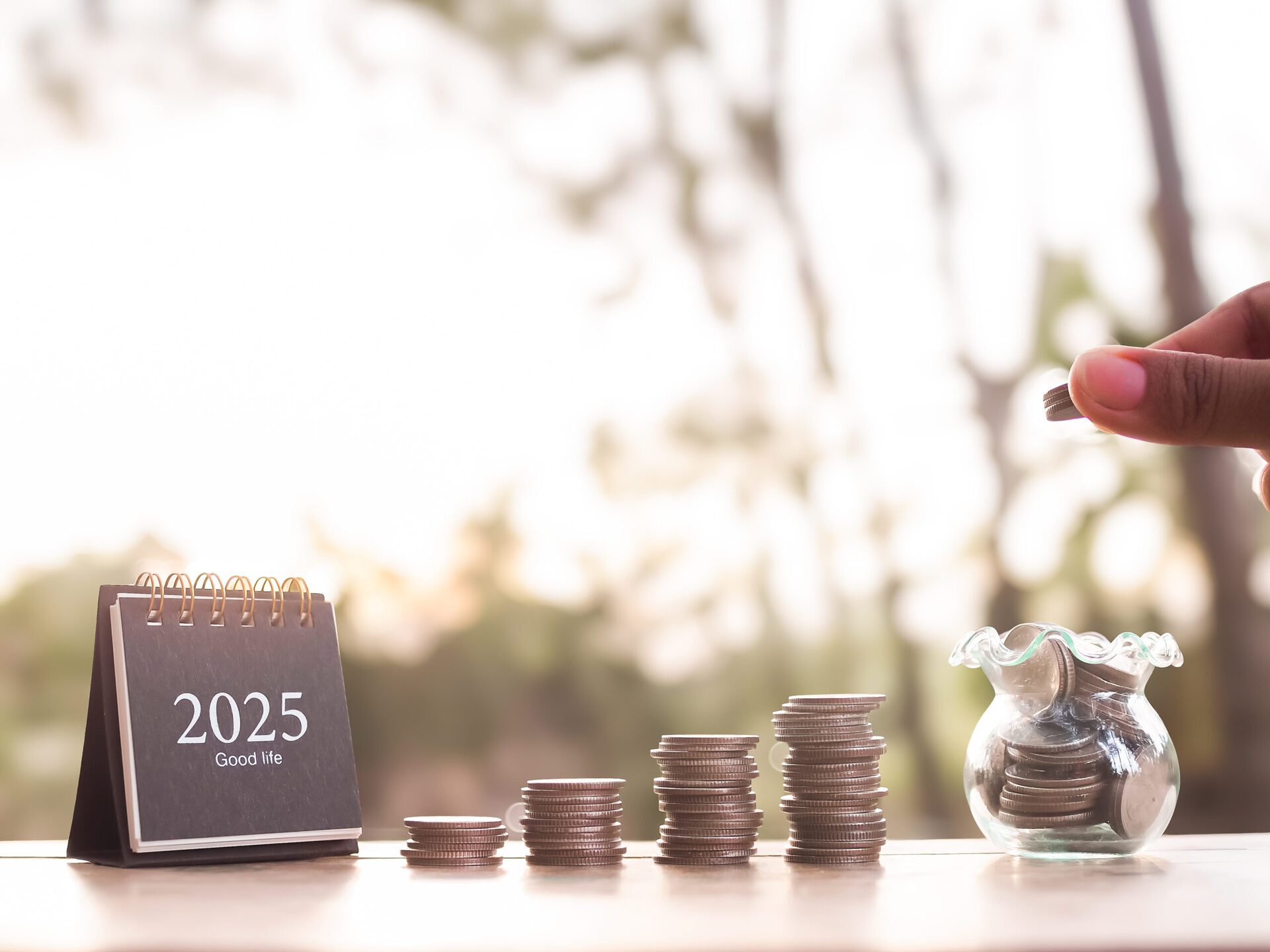 vecteezy_close-up-hand-putting-coin-into-glass-bottle-2025-desk_50104645