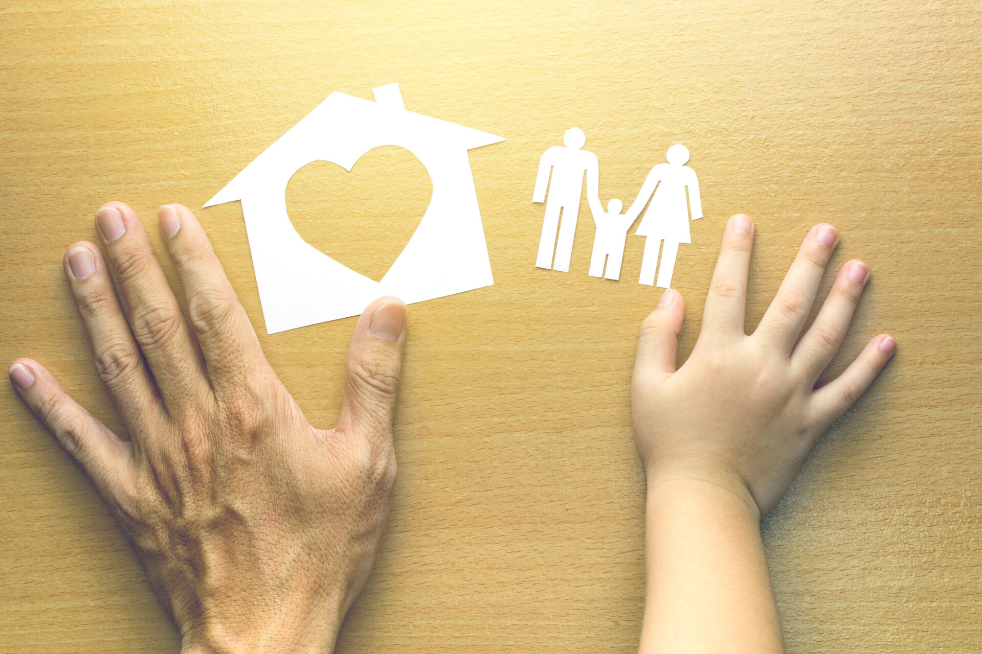 Father and Daughter hands with small model of house and family o