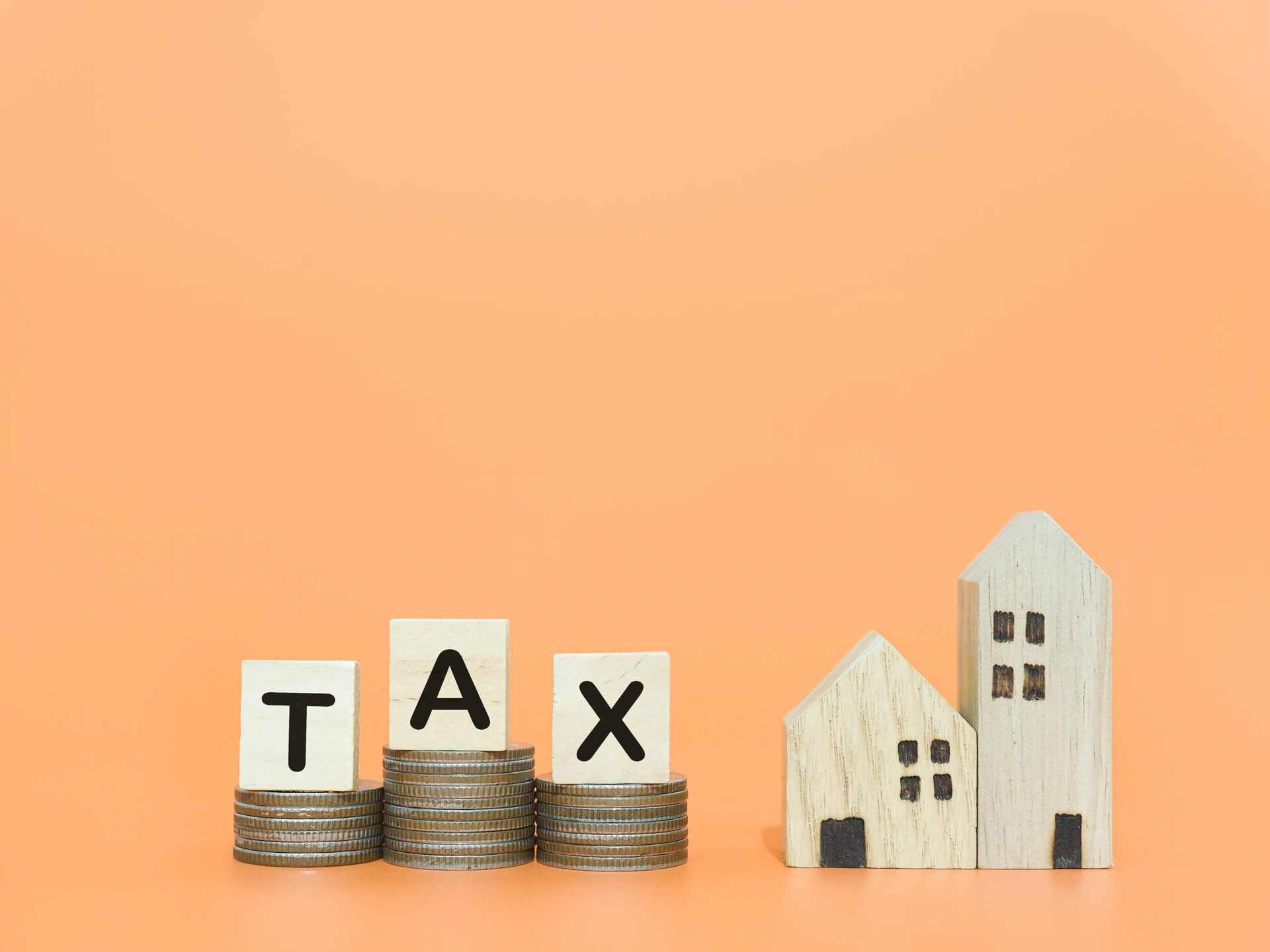 vecteezy_miniature-house-wooden-blocks-with-the-word-tax-and-stack_38560152